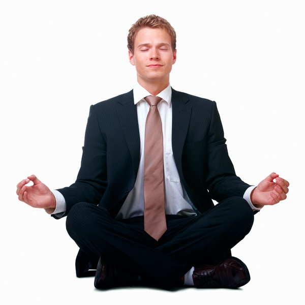 Businessman sitting in lotus position against white background